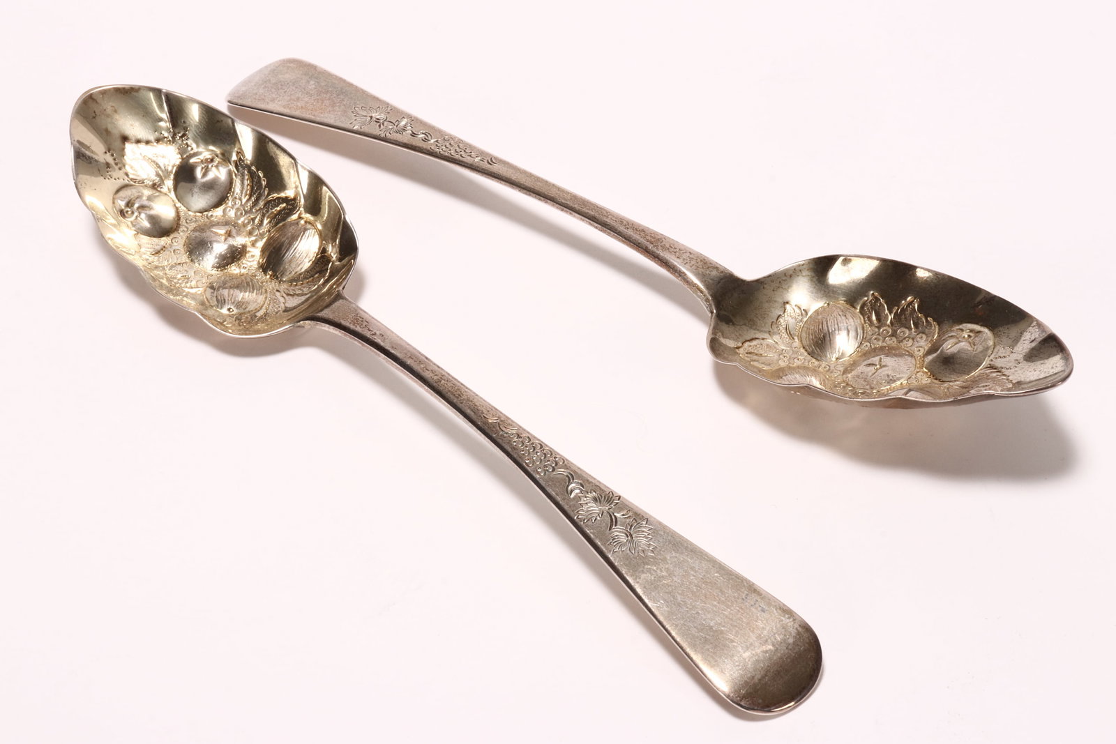 Pair of George III Sterling Silver Berry Spoons,: hallmarked London, 1824, I.W (James Wintle), in Old English pattern with embossed bowls, with engraved foliate motif to stem, total weight 109g, length 22.5cm (2)