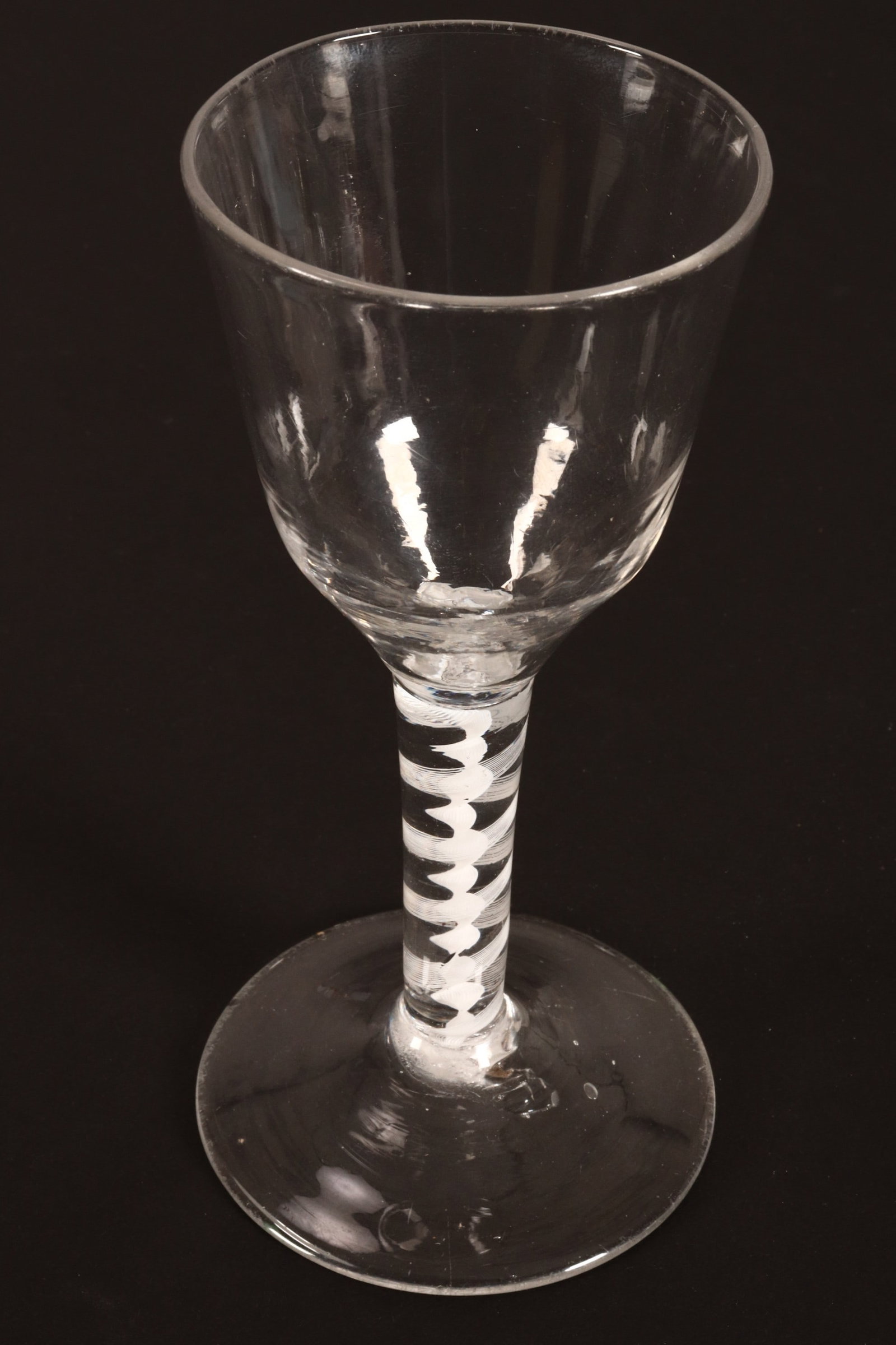 18th Century British Opaque Twist Wine Glass,: c.1765, with funnel bowl with slight molding, above a heavy stem with central corkscrew with spiral surround, on a circular foot, height 14.5cm
