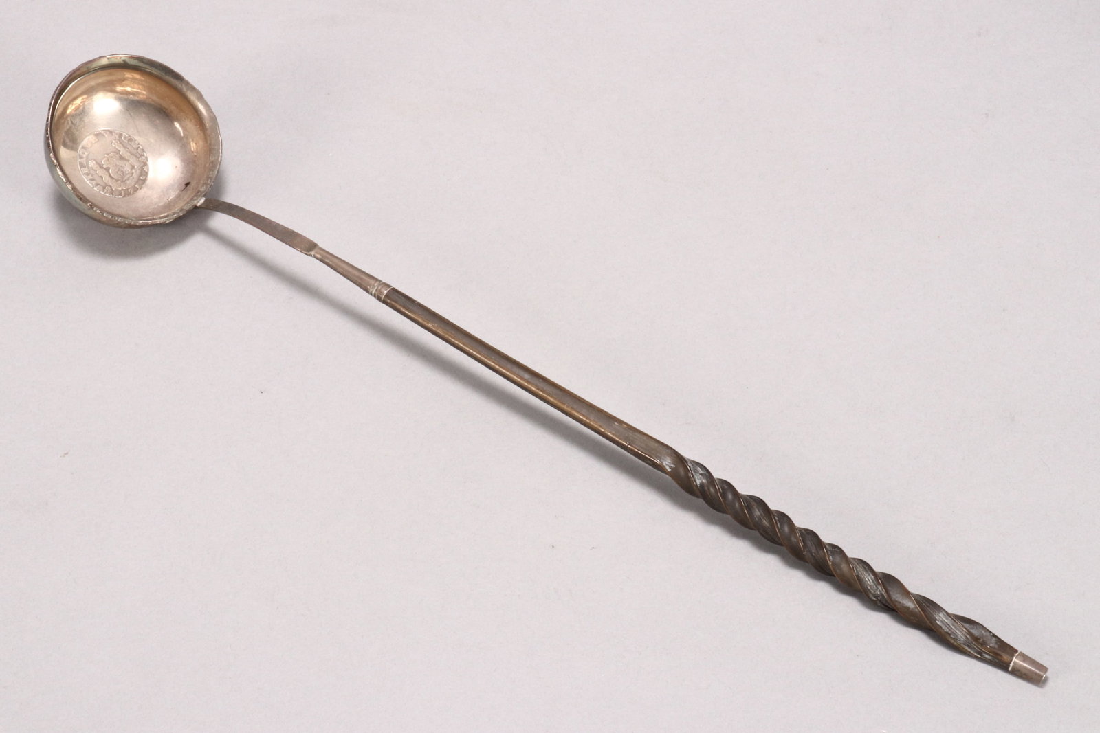 18th Century Silver and Baleen Toddy Ladle,: with twist handle, the circular bowl set with a Mexican coin dated 1739, length 37.5cm Provenance: The Estate of Dr. & Mrs.Thomas Tidswell.