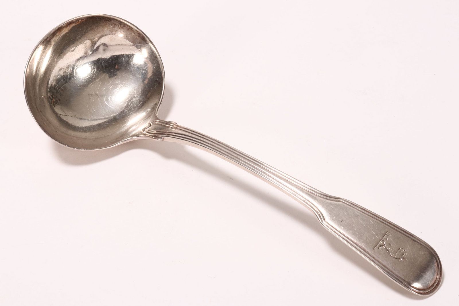 George III Sterling Silver Sauce Ladle,: hallmarked London, 1800, W.T (marks rubbed), in fiddle and thread pattern, with engraved crest rail and oval bowl, total weight 65g, length 18cm
