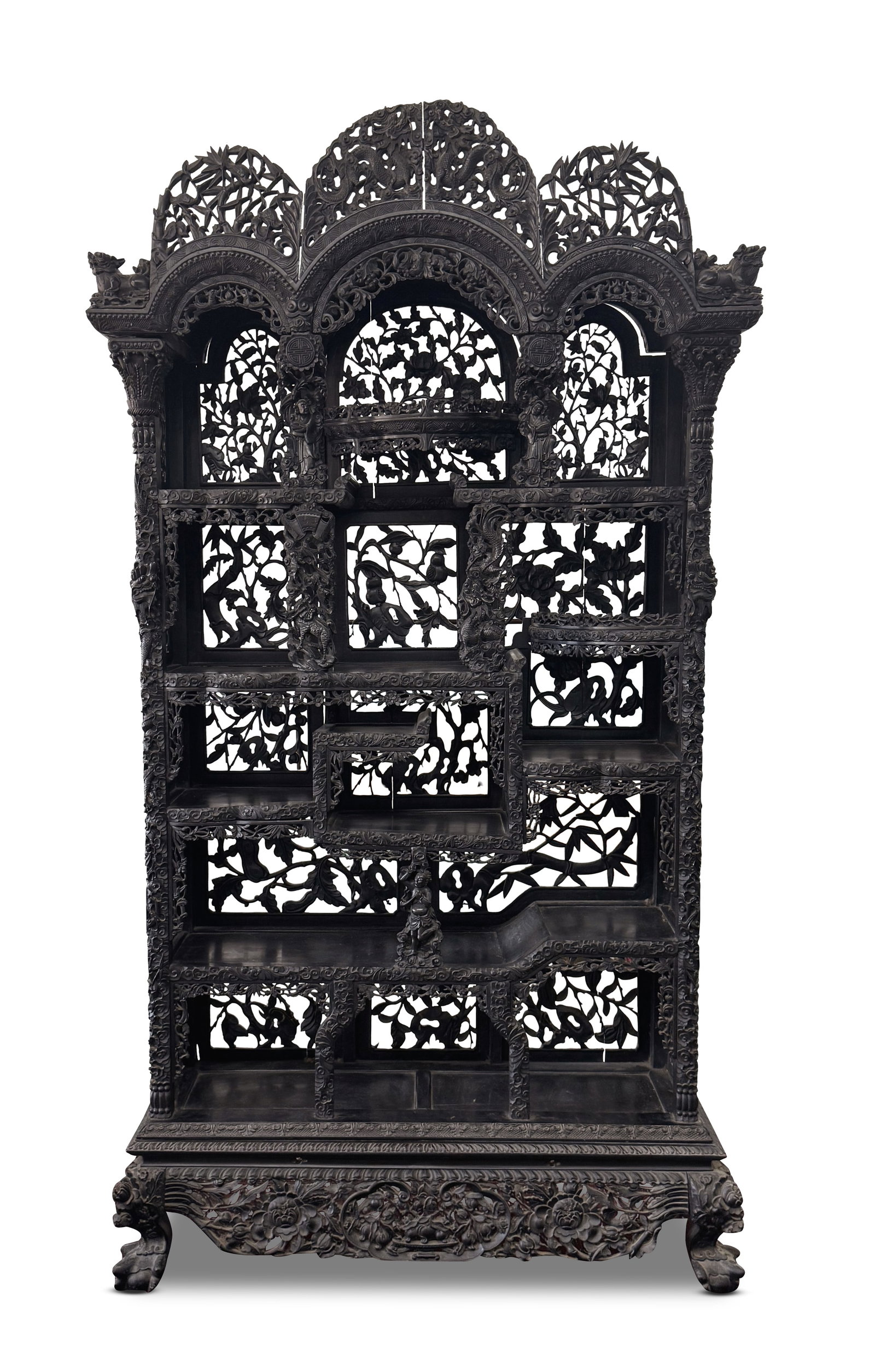 Impressive Chinese Qing Dynasty Ebonised Display Cabinet,: with a large scalloped pediment, carved with central twin dragons flanked by bamboo, cranes and kylin, raised upon a rectangular body set with various shelves and pierced back and sides, profusely car