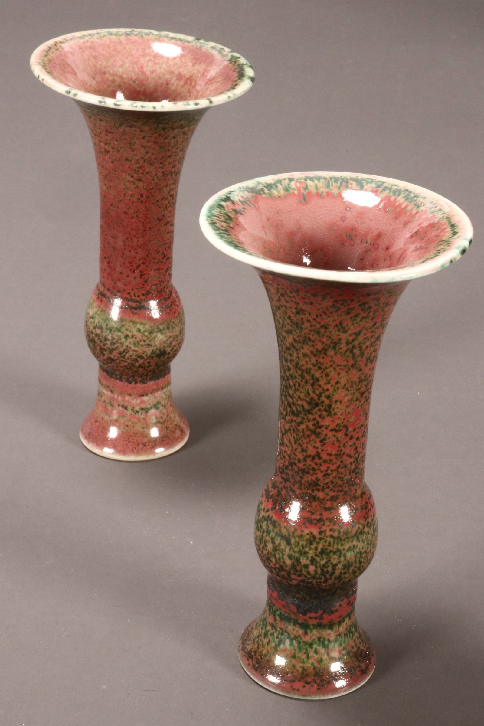 Pair of Chinese Peach Blossom Glaze Gu Vases,: of typical form, decorated with a mottled green and pale red glaze, six character mark to base, height 14.5cm (2)