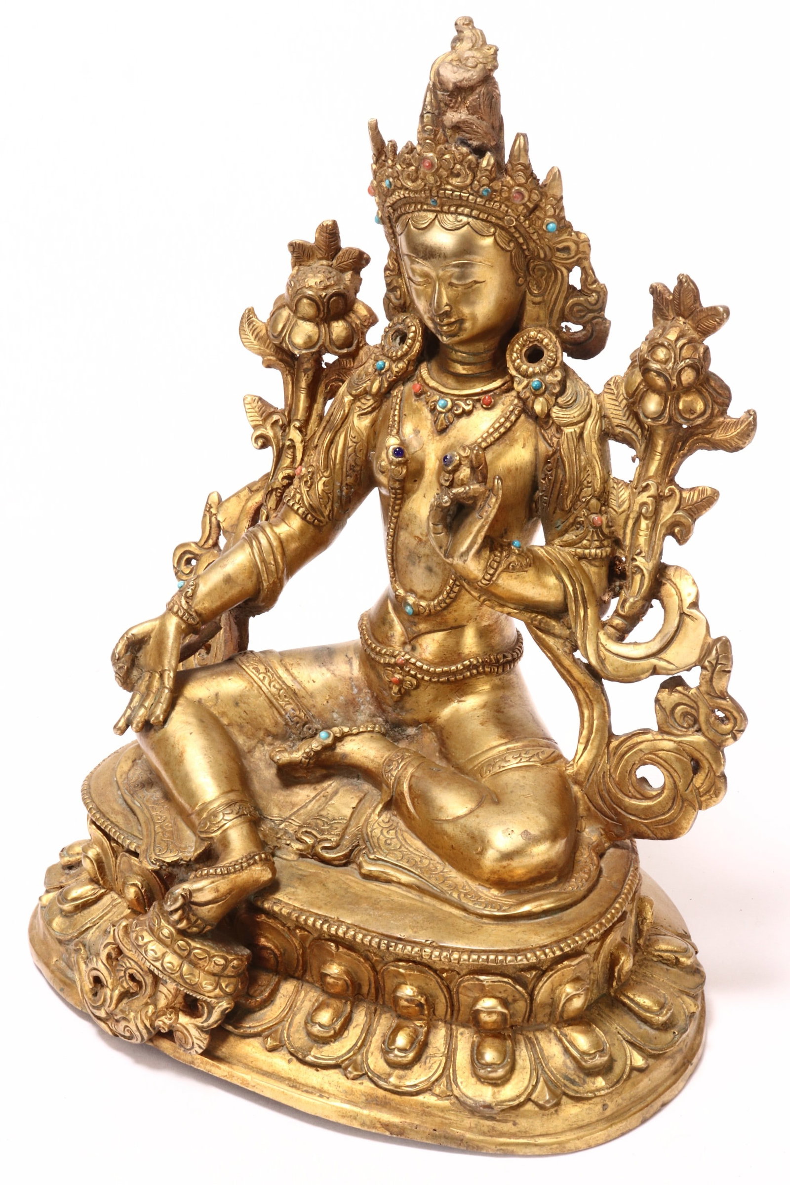 Sino-Tibetan Gilt Bronze Tara,: depicted seated with a downwards gaze and with hands in mudras, wearing robes and flanked by flowers and foliage, raised on a double lotus base, incised mark to base, height 22cm