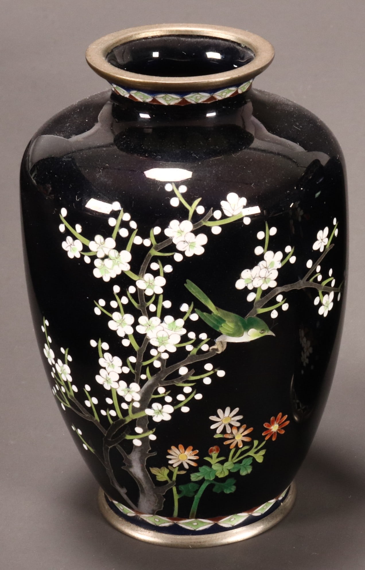Japanese Cloisonne Vase,: of baluster form with everted rim, decorated with bird perched amongst blossoming branches, above sprays of flowers and bamboo, flanked by decorative borders to the rim and foot, in polychrome tones o