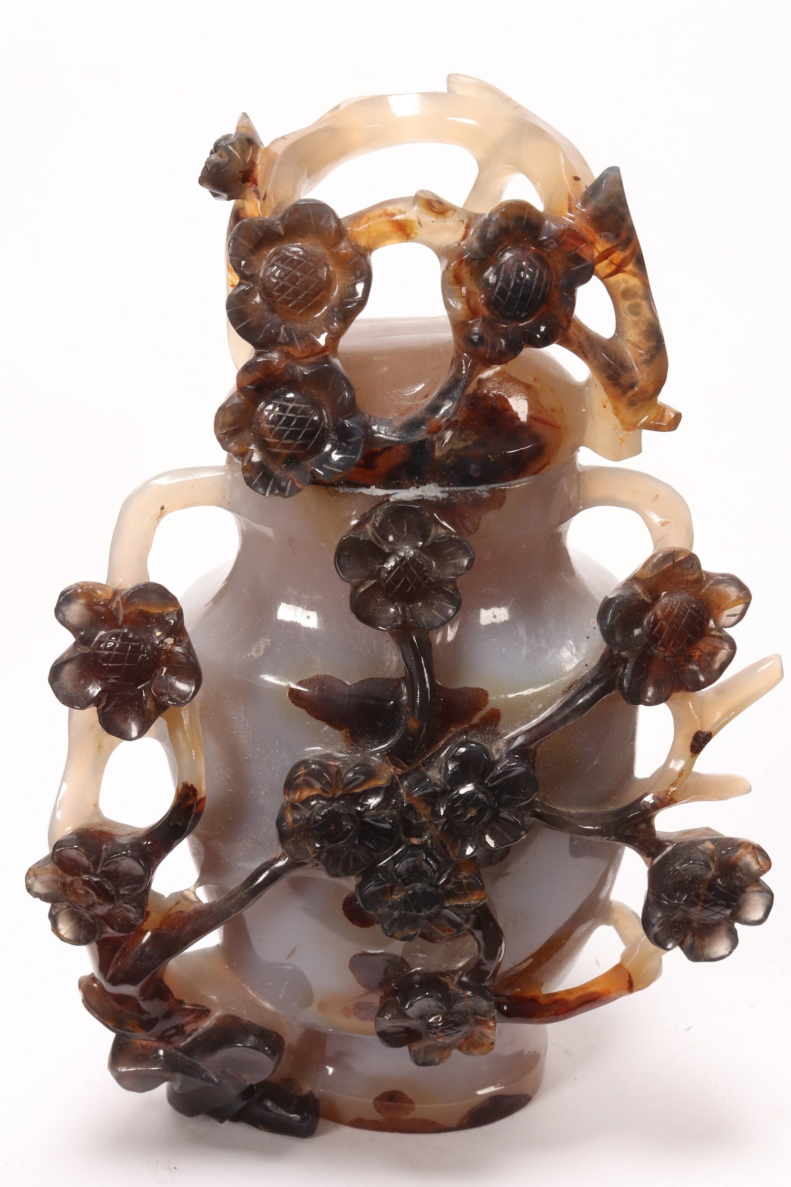 Chinese Carved Agate Vase and Cover,: of baluster form with tapered neck and domed cover, decorated with pierced flowers and foliage in relief, in tones of white, brown and orange, height 13cm
