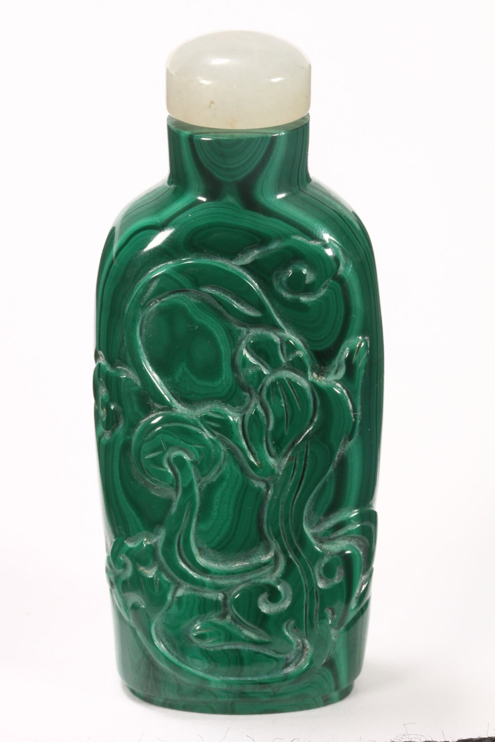 Chinese Carved Malachite Snuff Bottle and Stopper,: of tapered rectangular form, set with white jade stopper, the body carved in relief with a chilong amongst stylised clouds, height 8cm Provenance: The Estate of the Late James Gleeson AO, Bonhams and 