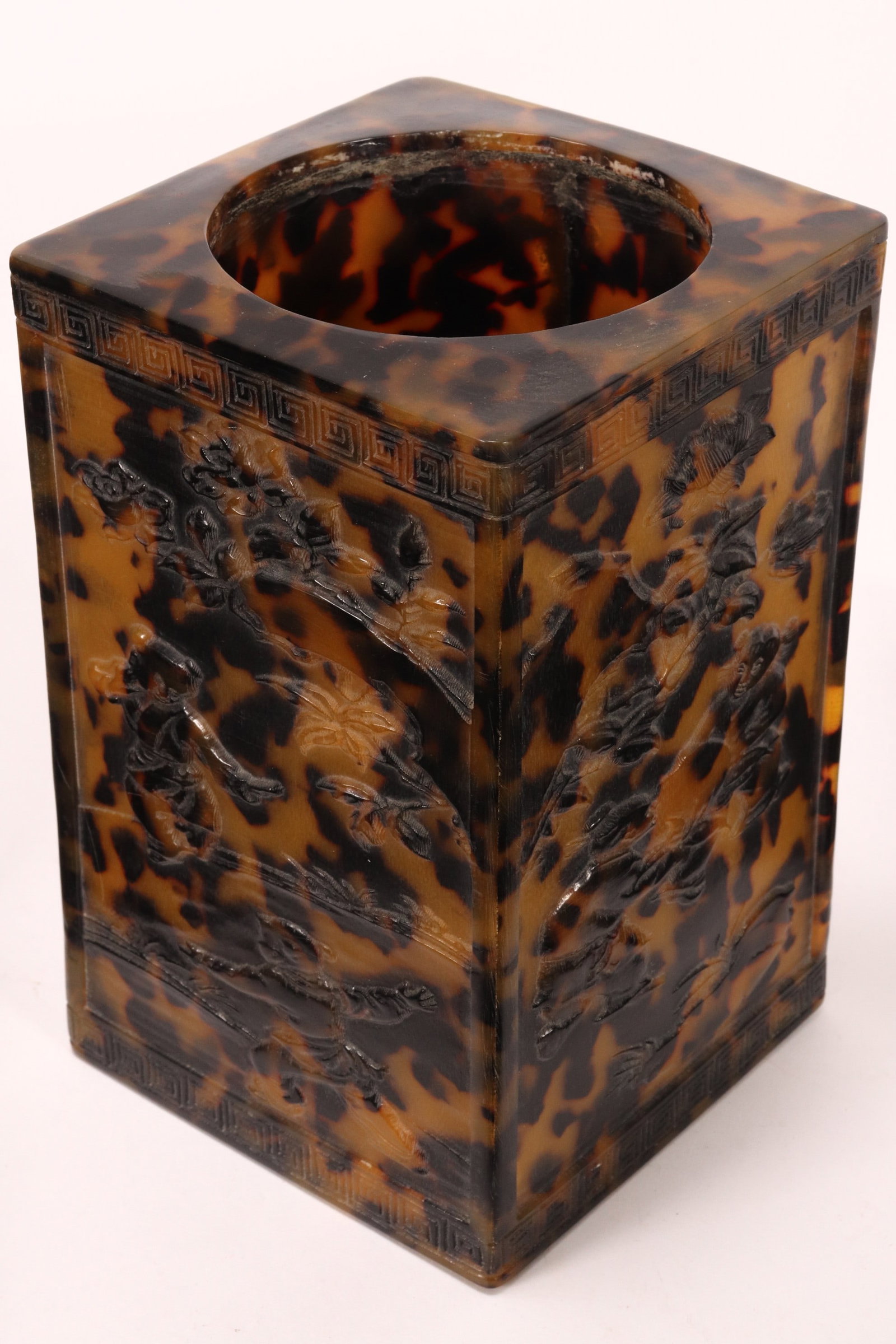 Chinese Tortoise Shell Brush Pot,: of rectangular form, decorated with four panels each depicting figures in an outdoor setting, with flowers and foliage, surrounded by a Greek key border, height 14.5cm