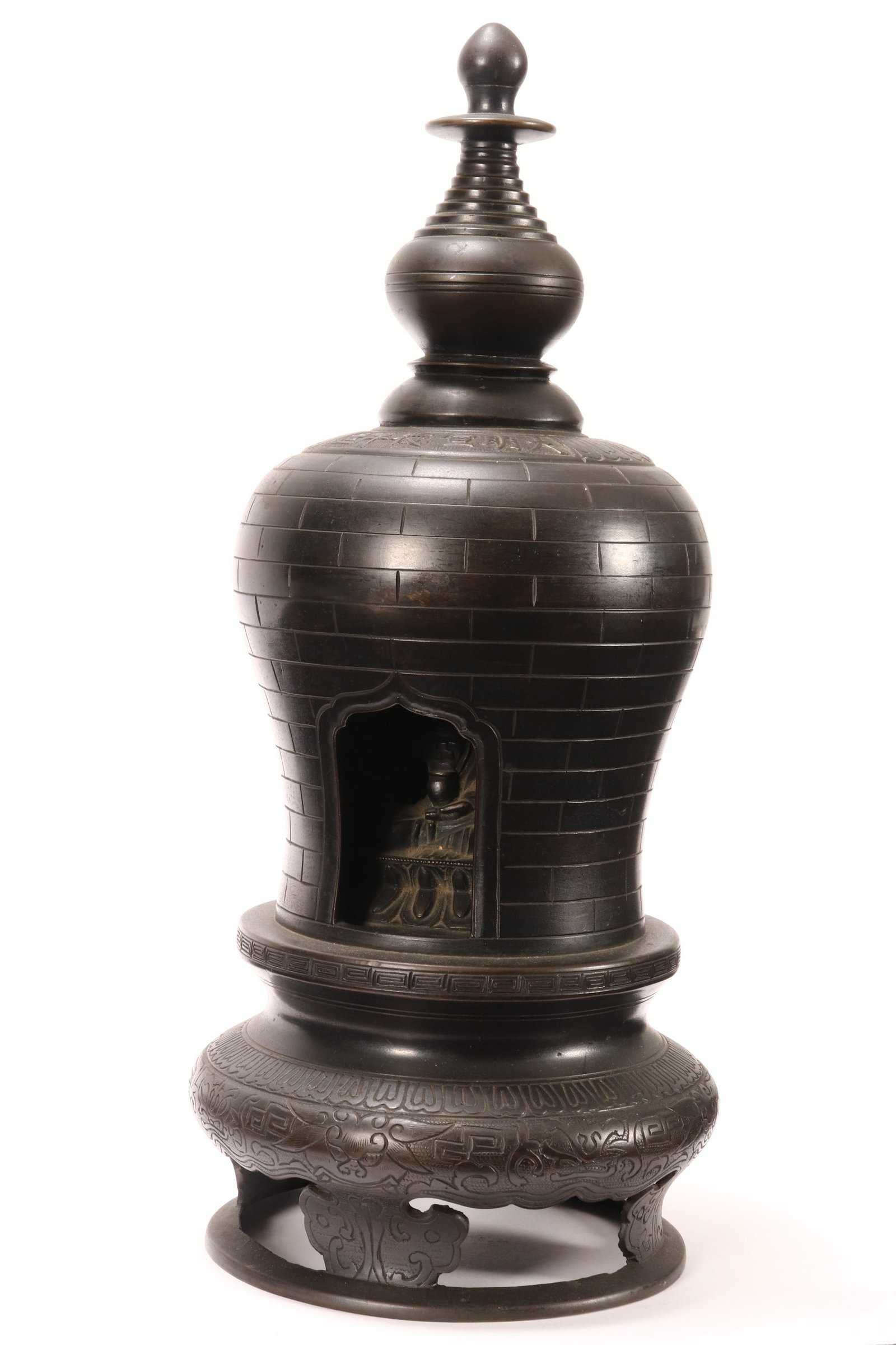Chinese Bronze Stupa,: set with large finial, above six character mark amongst lappets, the body decorated with geometric motif and revealing seated Buddha to interior, raised on a pierced base decorated with incised mythic