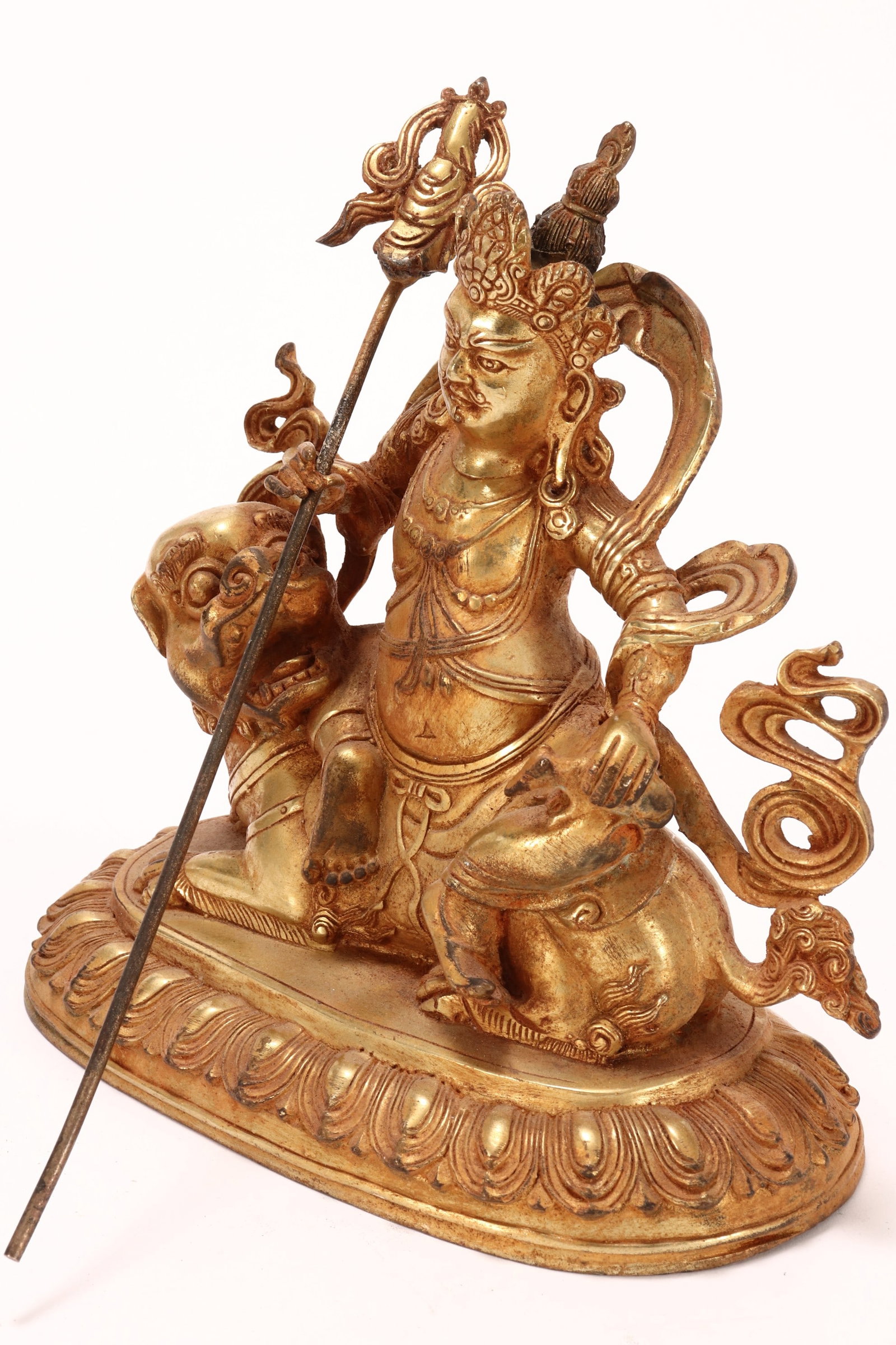 Sino-Tibetan Gilt Bronze Jambhala Figure,: depicted seated on a fo dog with a straight forward gaze, shown holding mongoose in left hand and a staff in right hand, raised on a lotus base, height 19cm