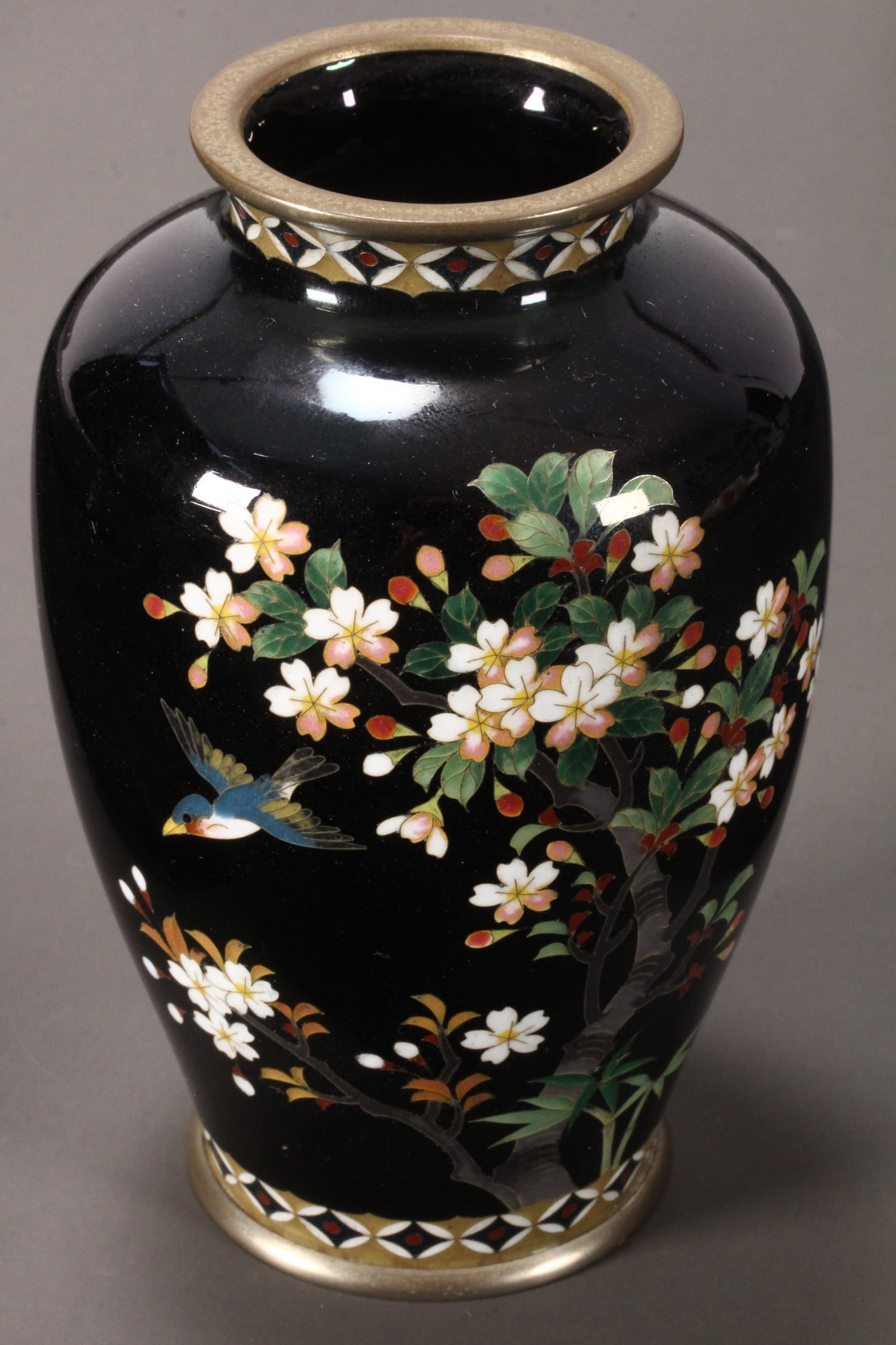 Japanese Cloisonne Vase,: of baluster form with everted rim, the body decorated with a kingfisher in flight amongst blossoming branches and sprays of bamboo, flanked by decorative borders to the rim and foot, in polychrome ton