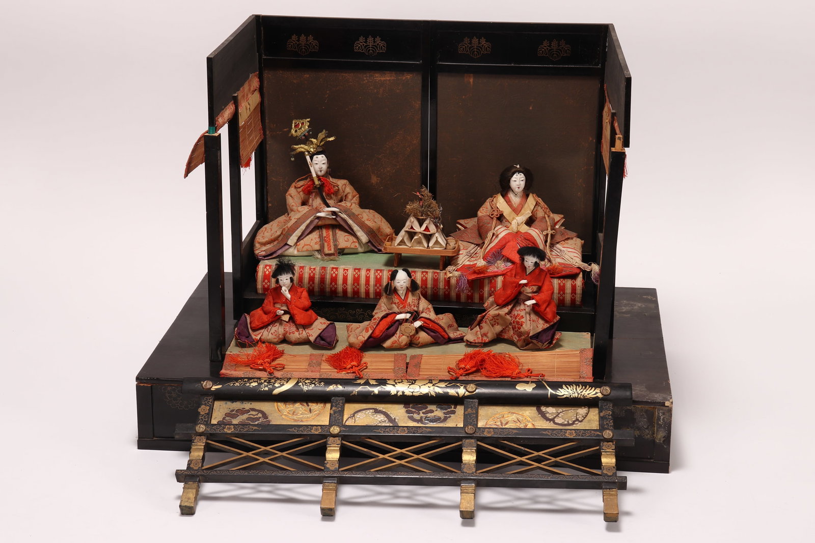 Japanese Hinamatsuri Laqcuer Altar Set,: of conventional stepped form, with open sides accented with sudare blinds, housing emperor, empress and court attendants, each in Heian period dress, a/f (missing pieces and breaks), 45cm x 46cm x 30c