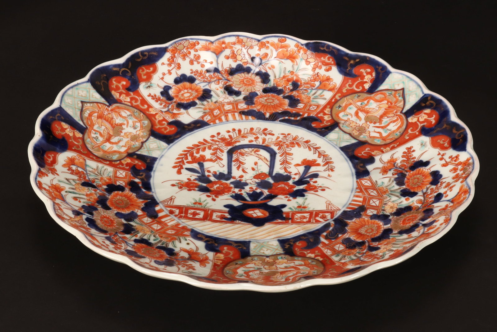 Japanese Late Meiji Period Imari Charger,: of shallow form with a scalloped rim, decorated with central medallion featuring a basket with flowers, surrounded by brocade border, in typical Imari palette, height 5.5cm and diameter 38cm