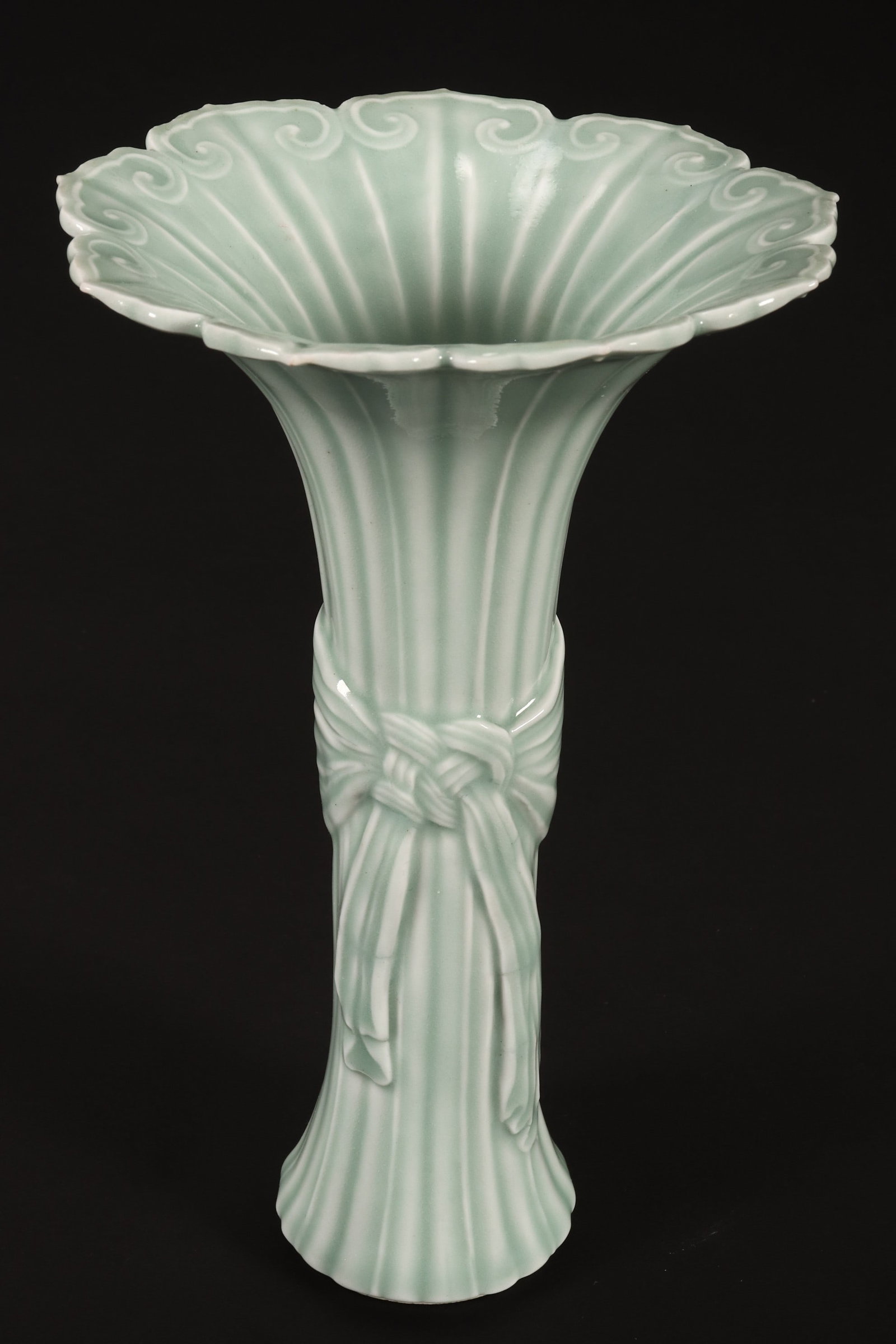 Chinese Celadon Trumpet Vase,: decorated with reeded body and sash tied around in relief, below ruyi heads to rim, raised on a circular base, seal mark to base, height 21cm