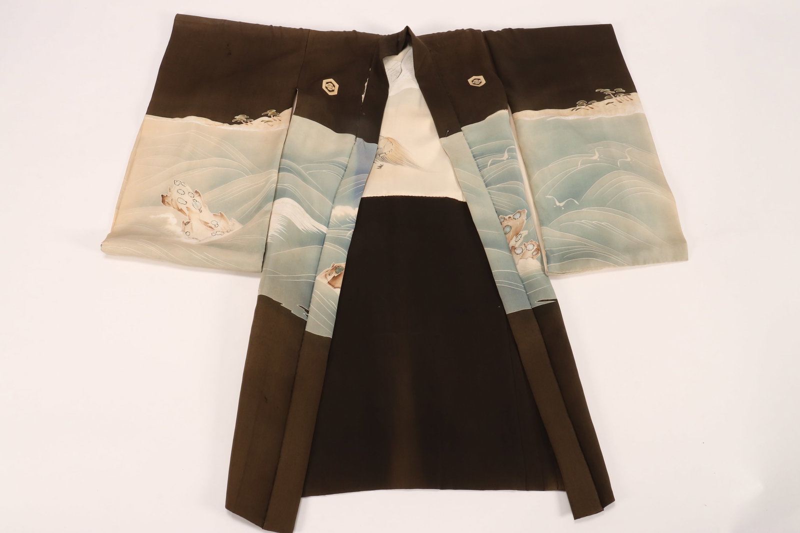 Japanese Children's Kimono,: the exterior decorated with floral reserves, above an ocean scene with birds in flight, the ushiro migori with a samurai on horseback, in tones of blue, white, brown and orange on an olive green groun