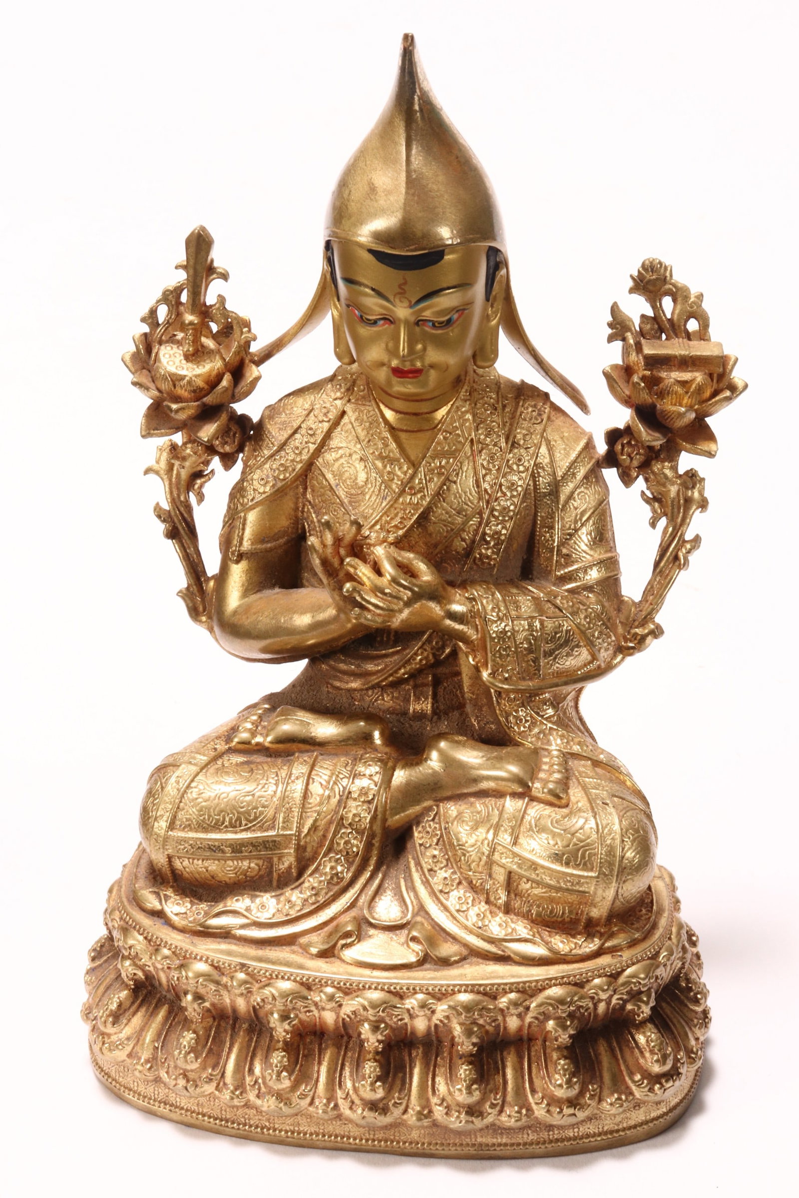 Sino-Tibetan Gilt Bronze Buddha,: depicted seated with a downwards gaze and hands in mudras, flanked by precious items, in tones of blue, orange, black and red on a gilt ground, raised on a double lotus base, marked to base, height 16