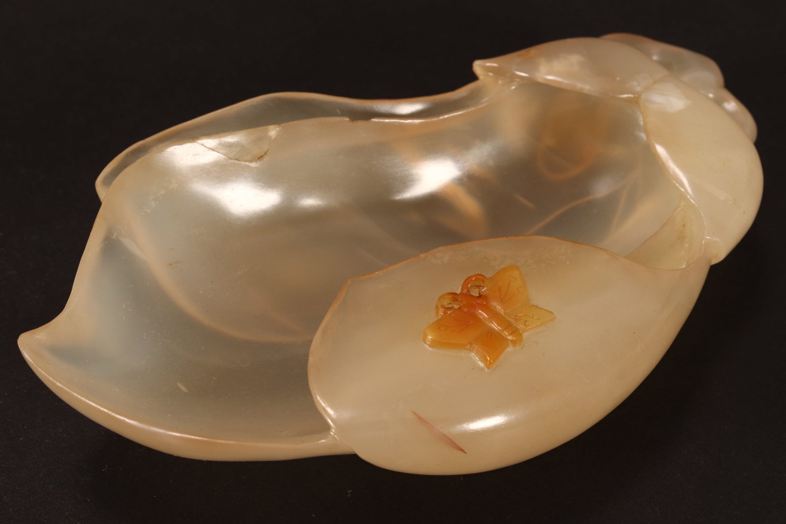 Chinese Carved Agate Brush Washer,: in the form of an eggplant flanked by foliage, decorated with butterfly to leaf in relief, in tones of white, orange and brown, 12.5cm x 7.5cm x 2cm