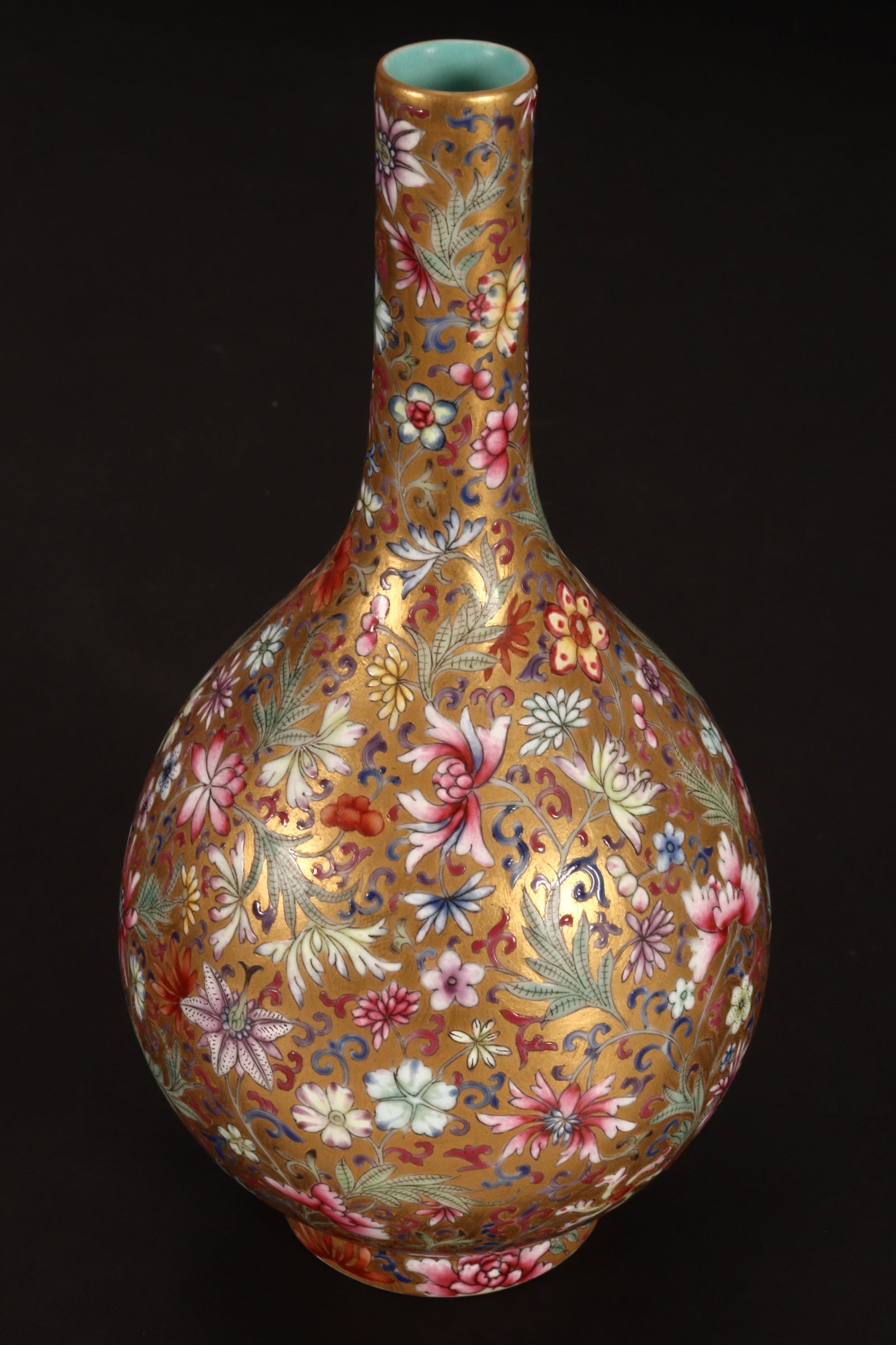 Chinese Thousand Flowers Porcelain Bottle Vase,: decorated continuously with flowers and foliage, in tones of pink, green, yellow, blue and purple on a gilt ground, standing on a raised circular foot, seal mark to base, height 17cm
