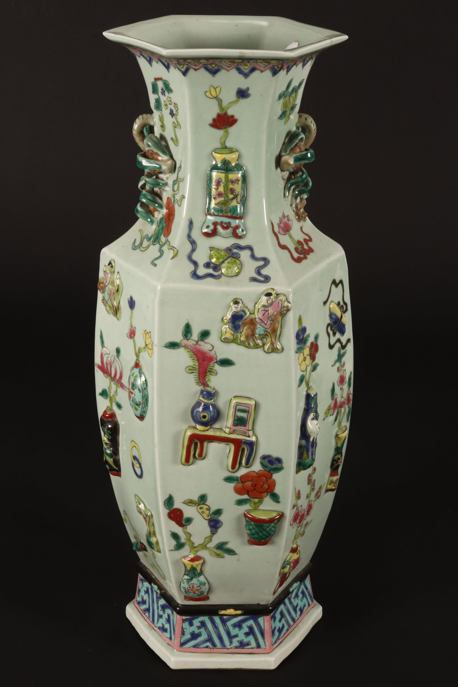 Chinese Porcelain Floor Vase,: of facetted form with twin pomegranate handles, decorated in relief with vases of flowers and attributes, in tones of blue, green and red on a pale celadon ground, six character mark to base, height 6