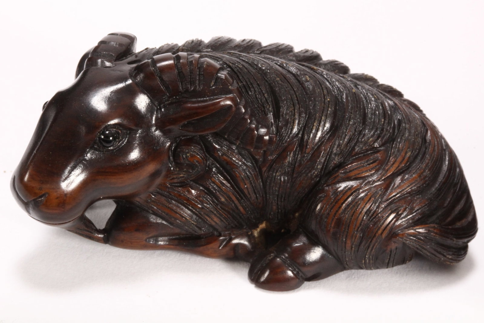 Japanese Carved Wooden Netsuke,: depicting a recumbent sheep, with incised hairwork to body, signature to base, length 6cm