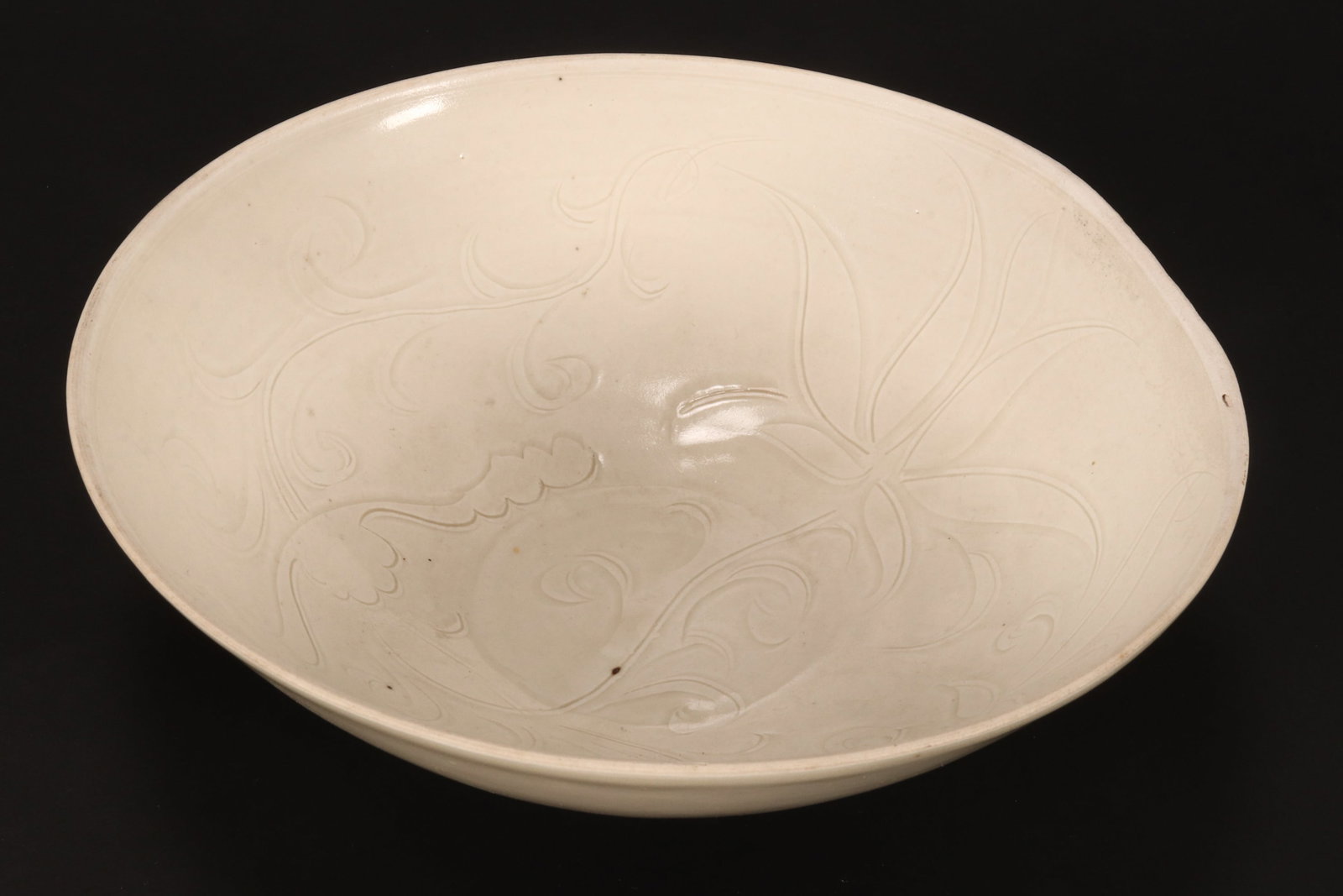 Chinese Ding Ware Bowl,: of circular form with deep sides, with incised lotus and lingzhi decoration to interior, raised on a circular foot, a/f, height 7.5cm and diameter 22.5cm