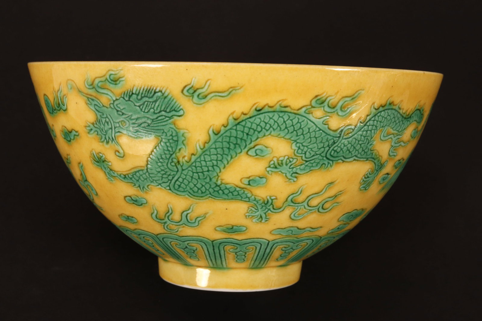Chinese Famille Jaune Porcelain Bowl,: of conventional form, decorated with central roundel containing symbol, the exterior decorated with continuous scene of dragons pursuing flaming pearl with phoenix amongst stylised clouds, standing on