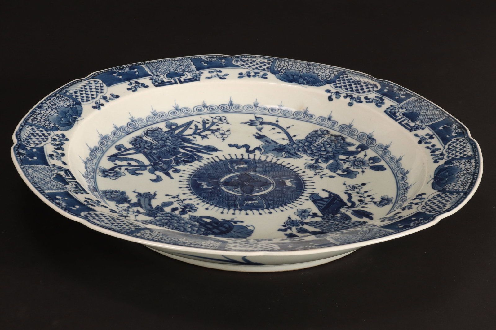 Chinese Blue and White Porcelain Charger,: of deep conventional form, with everted rim, the well decorated with central medallion, containing a flower and four mythical creatures, encircled by blossoming foliates and auspicious objects, the ri