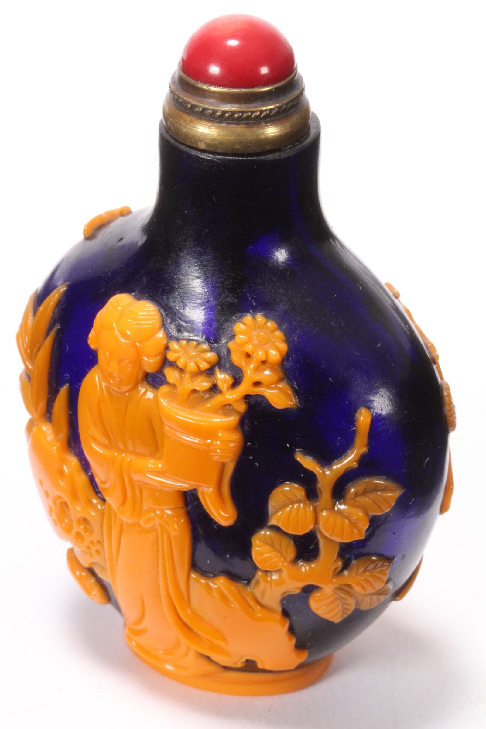 Chinese Cameo Glass Snuff Bottle and Stopper,: of compressed baluster form, set with coral stopper, the body decorated with scenes of figures amongst foliage, in orange tones on a deep blue ground, the whole raised above an elliptical foot, incise