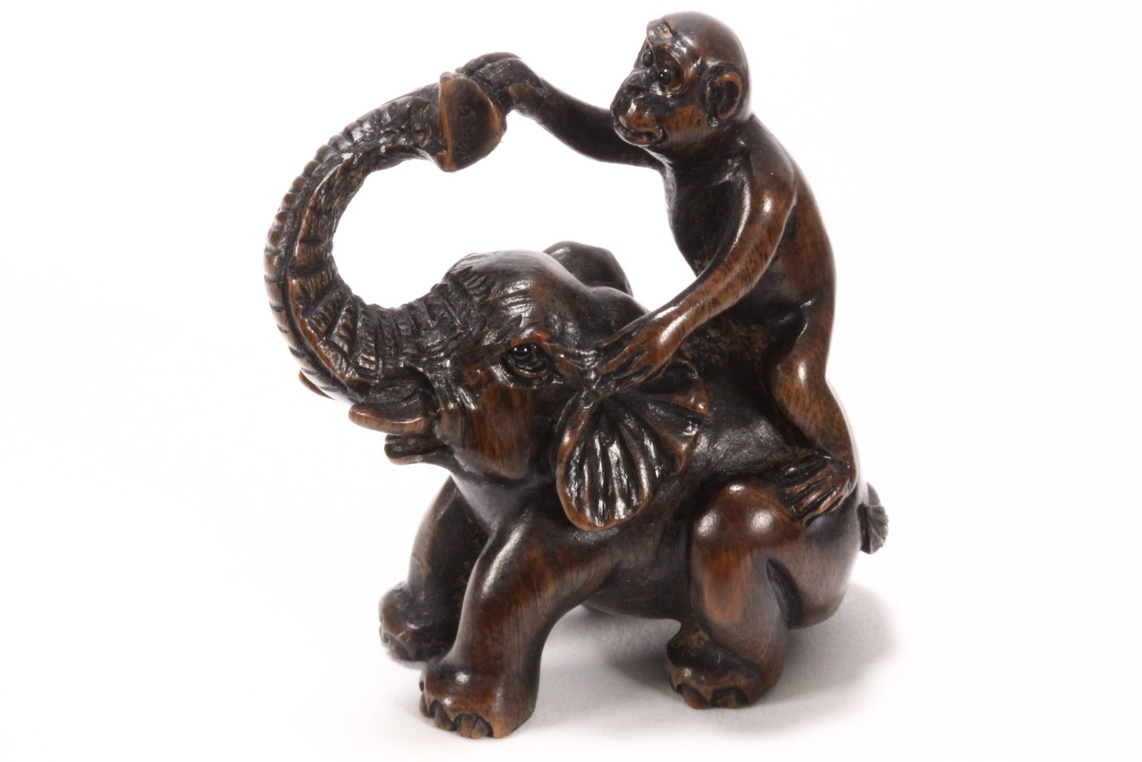 Japanese Carved Wooden Netsuke,: depicting a monkey balancing on the back of a seated elephant, unsigned, height 4.8cm