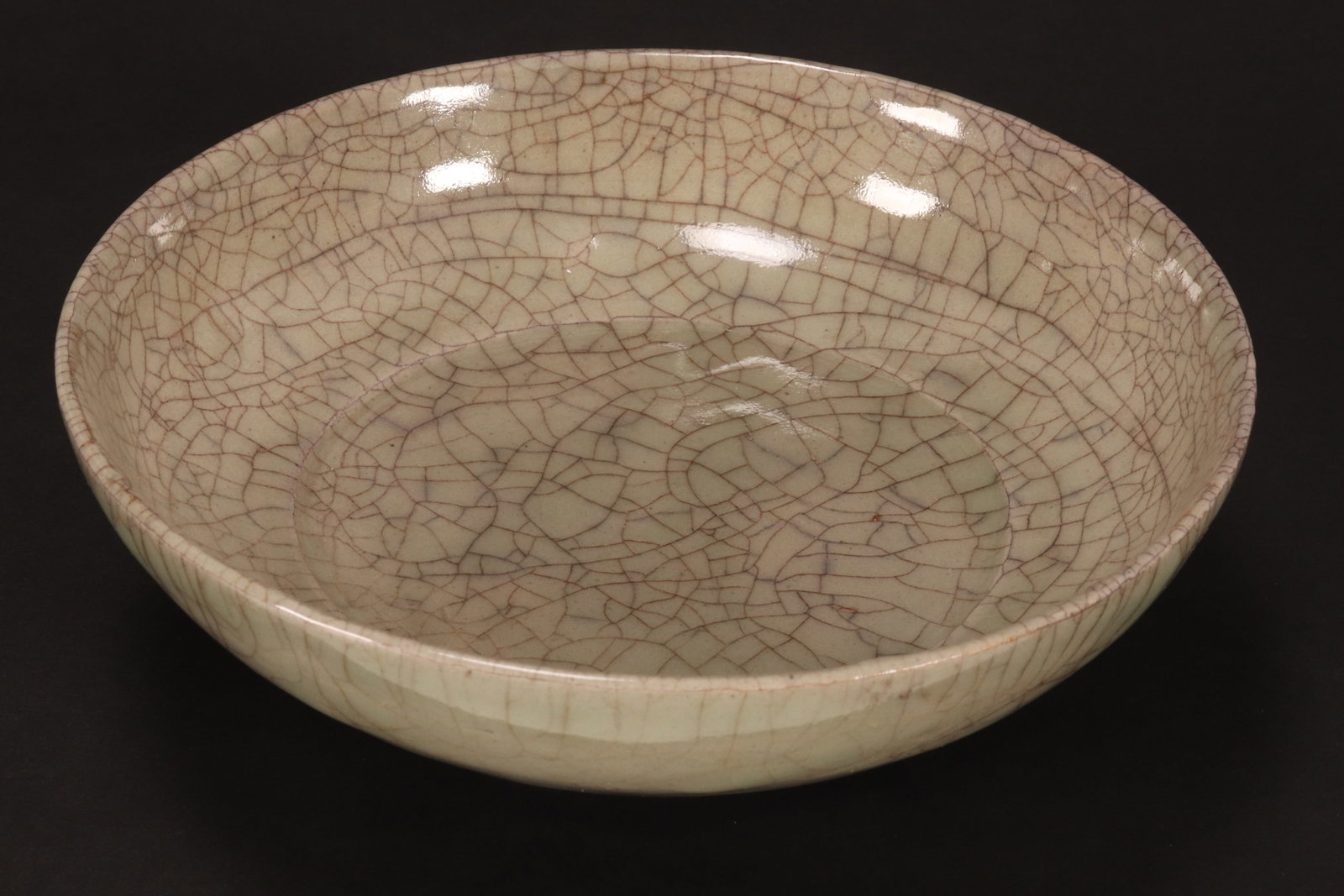 Chinese Celadon Crackle Glaze Bowl,: of shallow circular form, decorated with a pale green and grey crackle glaze, standing on a flat foot, diameter 17.5cm