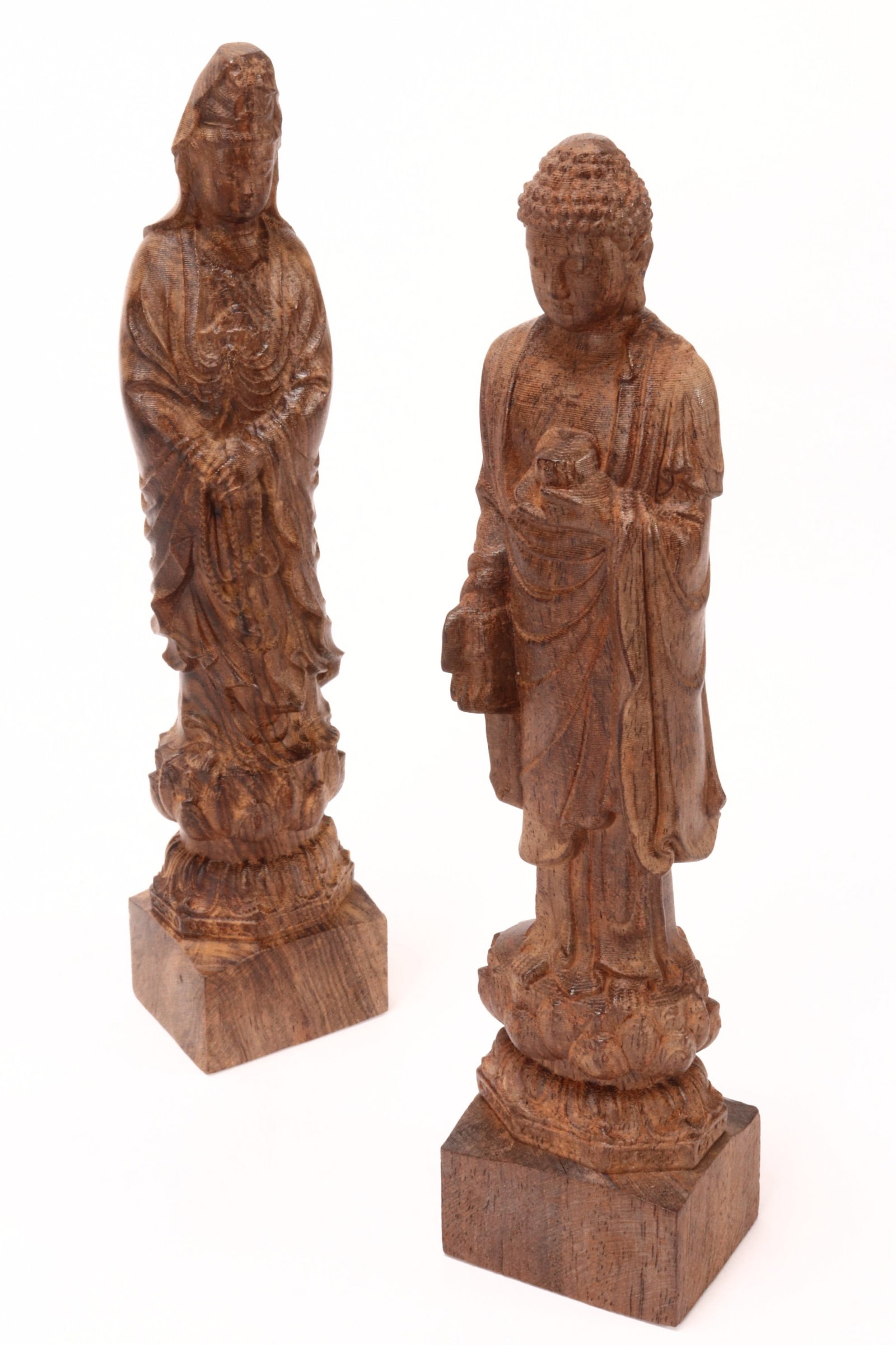 Two Chinese Carved Wooden Buddhist Figures,: in the form of a Buddha and Bodhisattva, each depicted standing with serene downwards gazing expression, holding auspicious items, above a double lotus pedestal, height 21.5cm (2)
