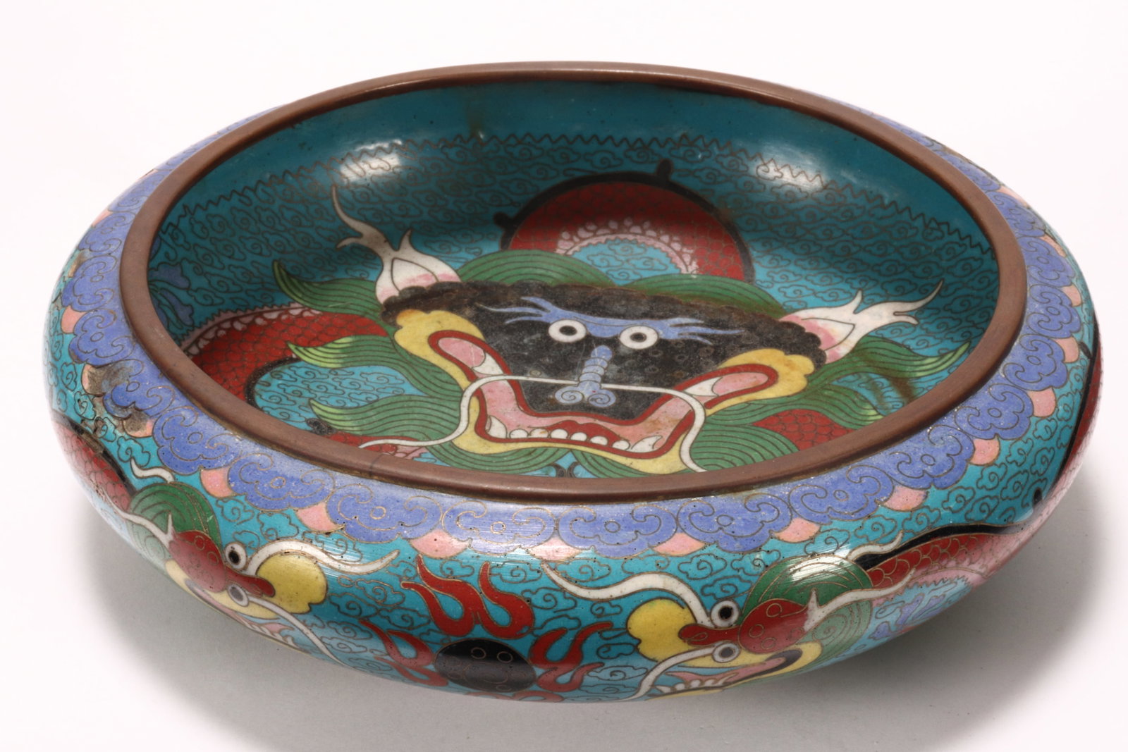 Chinese Cloisonne Brush Washer,: of shallow form, decorated with dragons and flaming pearl, in tones of red, black, yellow and green on a blue ground, a/f (chips), height 5.5cm and diameter 20cm