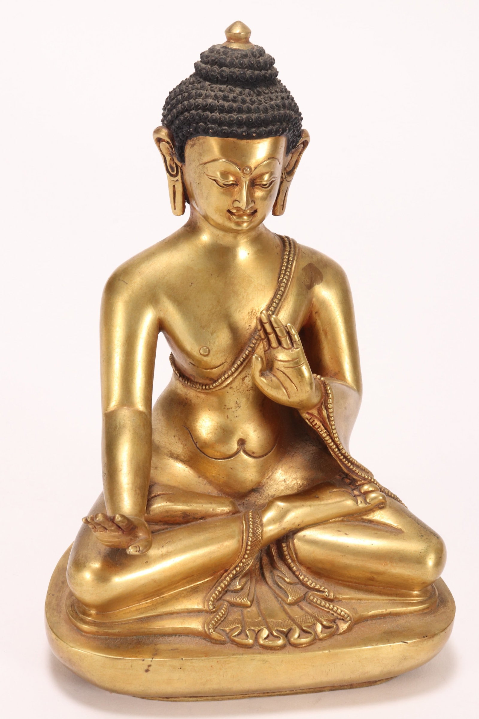 Sino-Tibetan Gilt Bronze Buddha Shakyamuni,: depicted seated with legs crossed and hands in mudras, with curled hair and serene expression on face, height 20.5cm