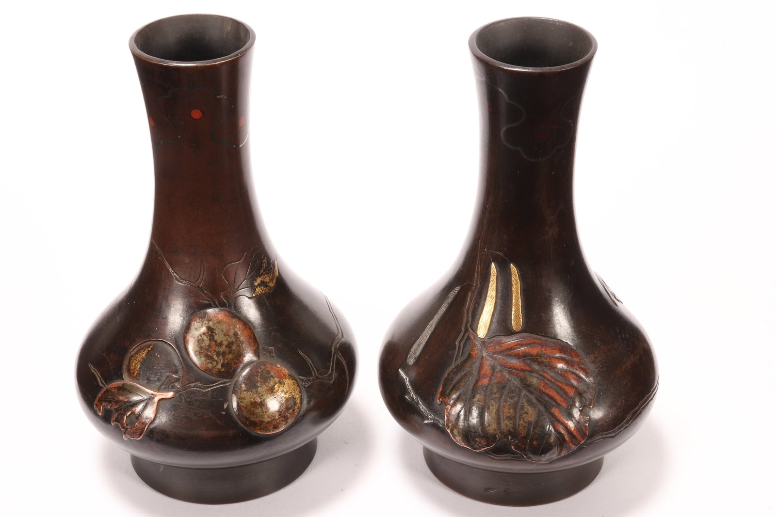 Pair Early 20th Century Japanese Bronze Vases,: of petite baluster form, decorated minimally with foliates in relief, with gold, silver and copper accents, height 10.5cm (2)