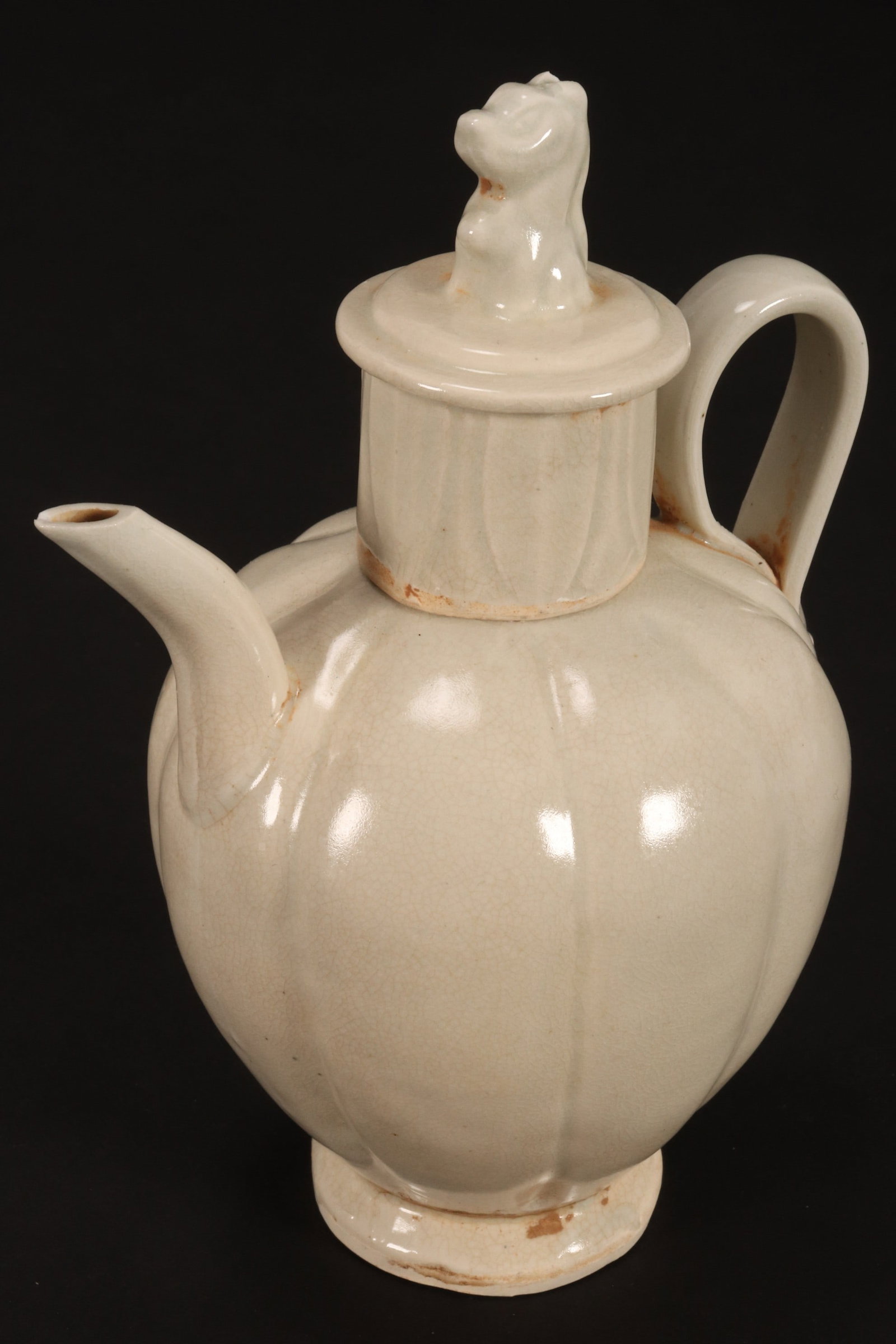 Chinese Pale Celadon Ewer,: of lobed baluster form, with cylindrical cover set with fo dog finial, with palmette decoration, raised on a circular foot, total height 16.5cm