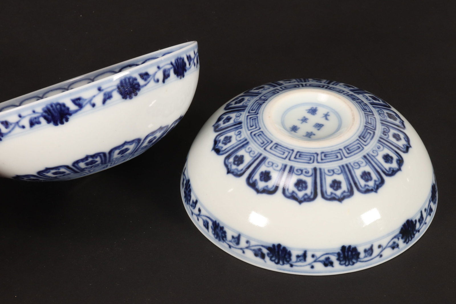 Pair of Chinese Blue and White Porcelain Bowls,: of shallow circular form, decorated with scrolling and ruyi head patterns, with floral and foliate border to exterior rim, six character mark with in double rings to base, diameter 13cm (2)