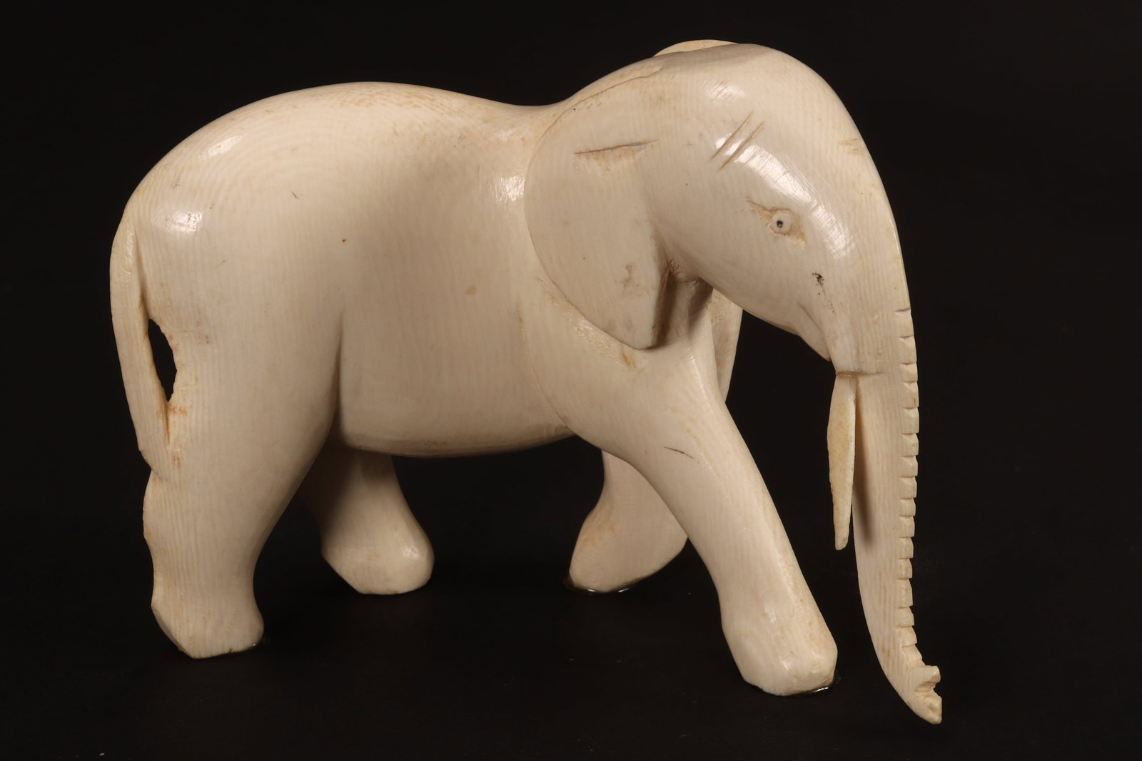 Carved Elephant,: depicted standing with trunk pointing downwards, a/f (crack to top), height 8.5cm and length 12cm. Please note this item can only be shipped WITHIN Australia.