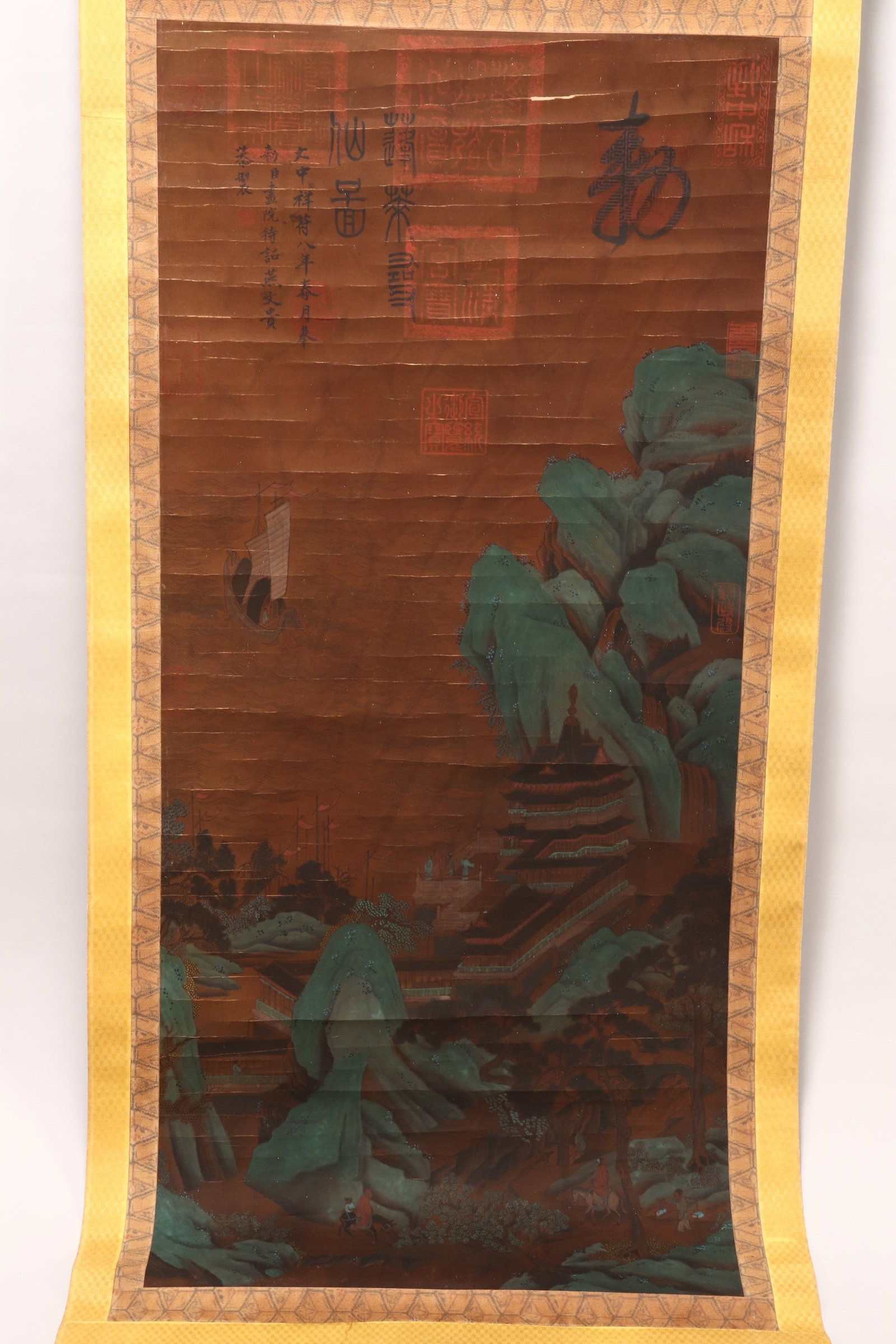Chinese Silk Scroll,: of rectangular form, painted with a scene of boats returning to a seaside town, with traversing figures and pavilions, in tones of green, red and brown, on a warm brown ground, with inscription and se