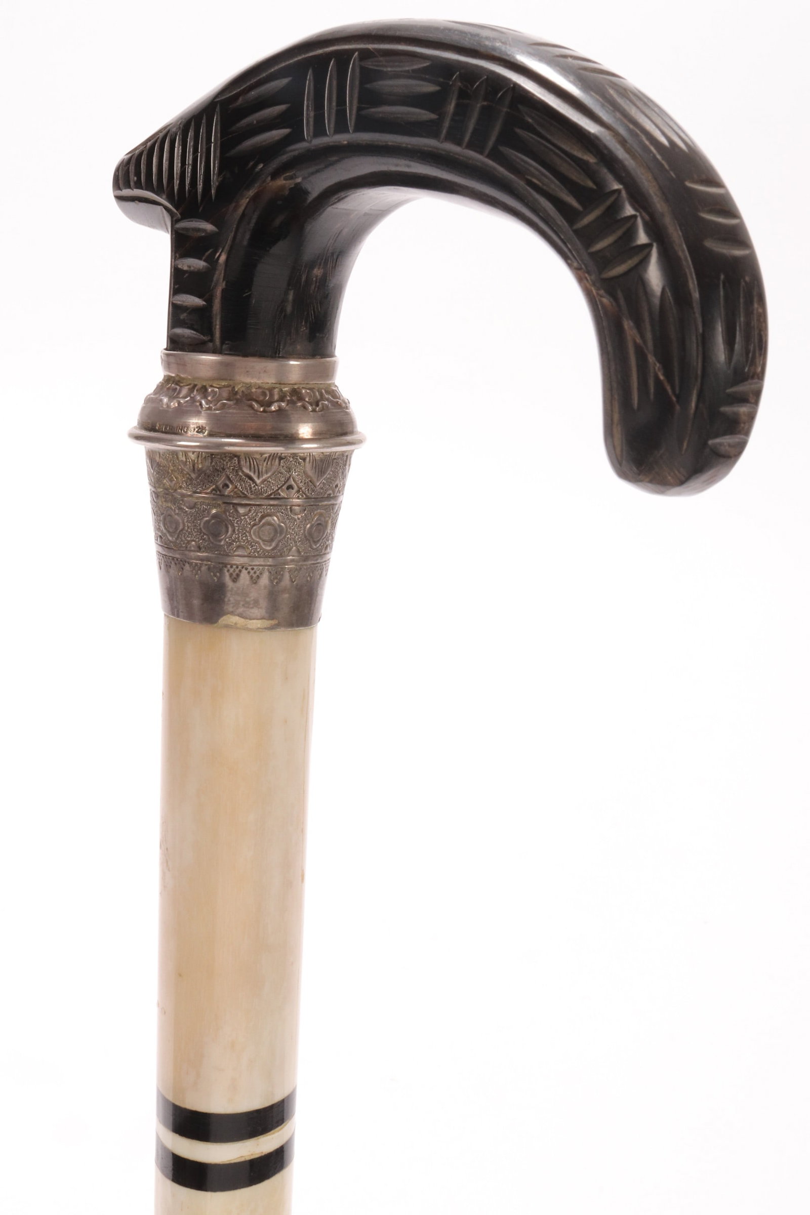 Chinese Sterling Silver and Horn Walking Stick,: the derby style handle, set above a sterling silver mount, marked "Made in Israel Sterling 925", with chased foliate decoration, continuing to a tapering horn support, with inlaid banding, length 93.5