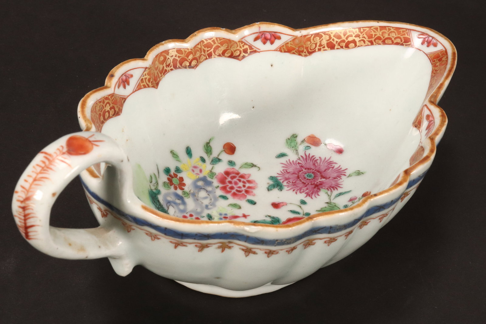 Chinese Export Ware Porcelain Jug,: with a scalloped rim, decorated in polychrome enamel with flowers, foliage and rocky outcrop, British Antique Dealers Association label to base, height 8cm and length 19.5cm