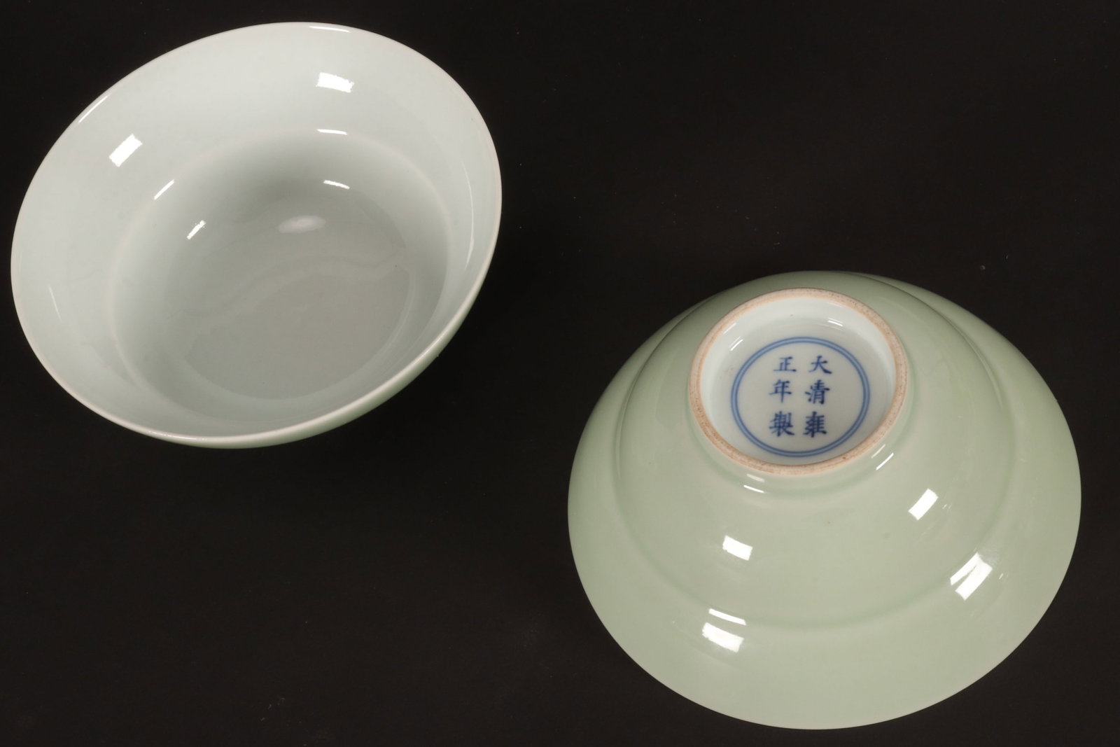 Pair of Chinese Celadon Porcelain Bowls,: of shallow circular form with large flared rim, decorated with pale green exterior and white interior, standing on a raised circular foot, six character mark within double rings to base, height 5.5cm 