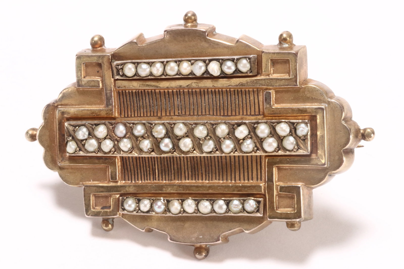 Edwardian 9ct Gold Seed Pearl Brooch,: unmarked (acid tested 9ct), of elliptical form with beading to border, containing an internal geometric design with three rows of seed pearls, divided by incised linear designs infilled with black, th