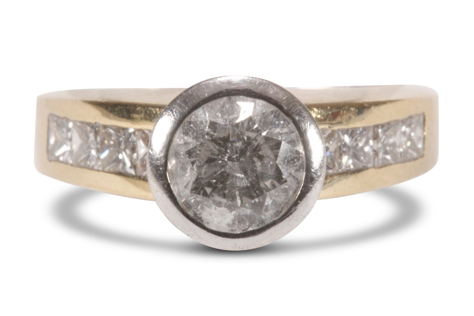 18ct Gold 1.29ct Diamond Ring,: stamped 750, featuring a 1.29ct round brilliant cut diamond (colour H/clarity P1), in a white gold bezel setting, above an 18ct yellow gold band channel set with eight princess cut diamonds totaling 0