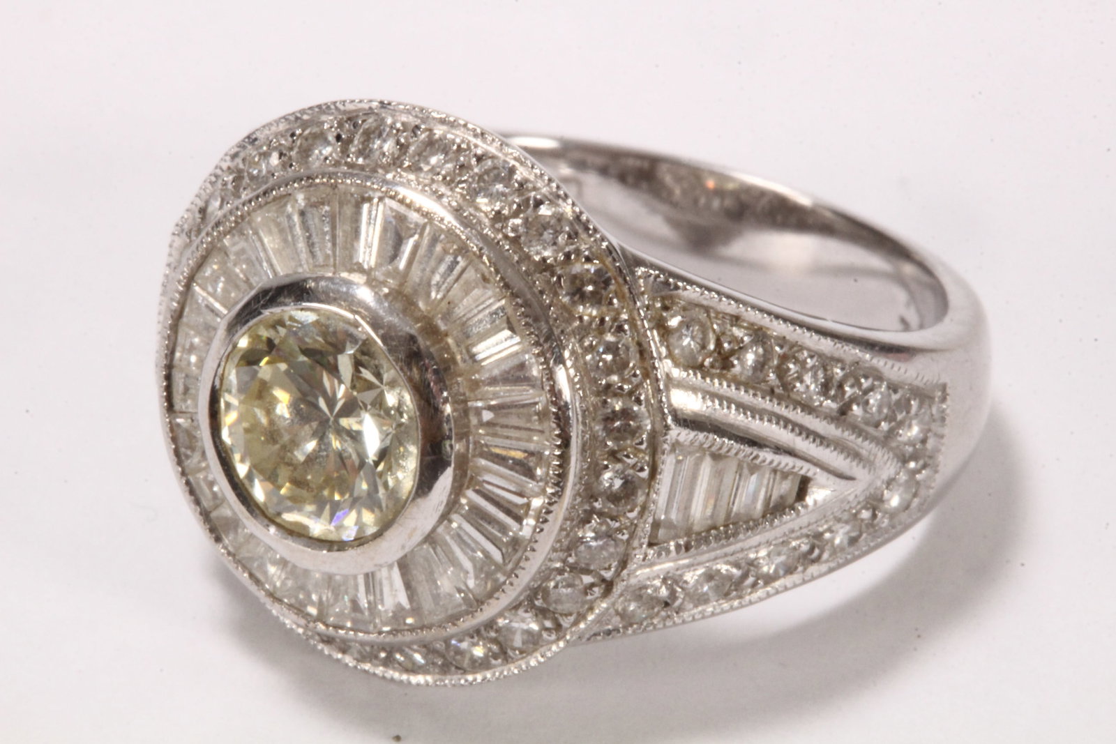 18ct White Gold Art Deco Style Diamond Ring,: stamped 18k, #5242, IN, featuring a bezel set 1.00ct round brilliant cut diamond (colour K/L - clarity VS2), encircled by radiating borders of baguette and round brilliant cut diamonds, (colour G/clar