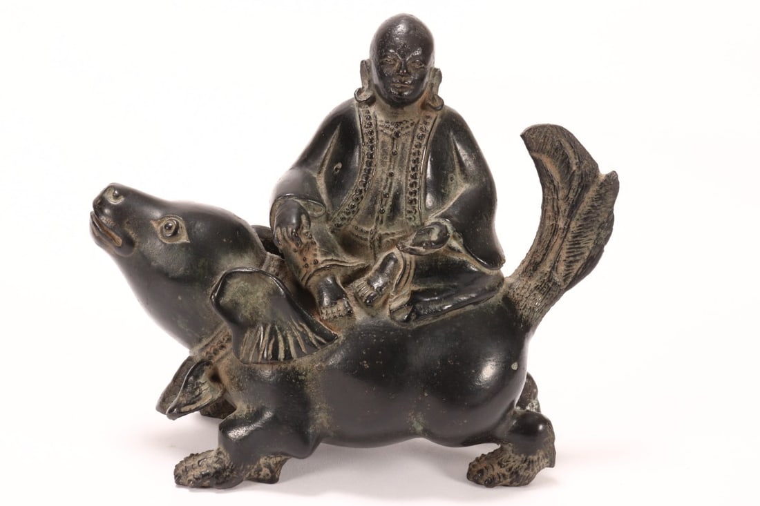 Wonderful 19th Century Sino-Tibetan Lohan,: depicted with lobed ears, earrings and necklace, seated on crouched mythical beast with necklace, 17cm x 14cm