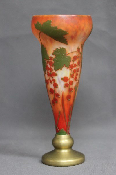 Good Daum Nancy Cameo Glass Vase,: of trumpet form, decorated with berries and flowers, in tones of red, and green on a mottled orange ground, on a gilt bronze stand, signed, h 29cm