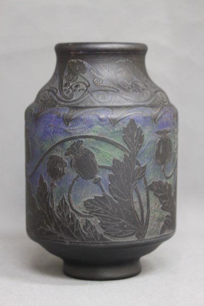 Large Daum Nancy Cameo Glass Vase,: with a sloping neck and shoulders with cut arabesque motifs, above a cylindrical body with cut poppy and foilage, in tones of purple, green and black, signed, h 26cm