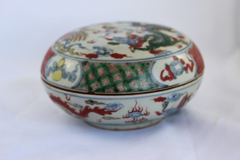 Chinese Round Wucai Glaze Box and Cover,: of bun form, decorated with a rampant dragon and phoenix surrounded by lattice ground, six character mark to base, d 16cm