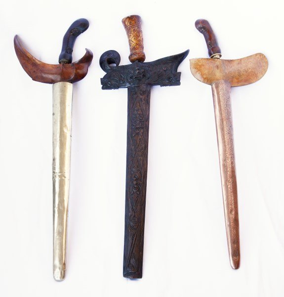 Three Indonesian Wave Bladed Krises,: including old Balinese souvenir Kris with barong carved sheath, and old seven wave Sumatran Kris and an eighteen wave Javanese Kris with copper sheath, (3)