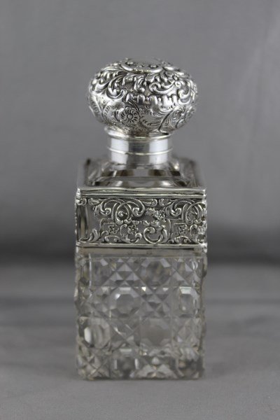 Edwardian Sterling Silver and Crystal Perfume: Bottle and Stopper, with embossed spherical stopper, above a facetted body, with silver pierced mount, a/f, h 15cm