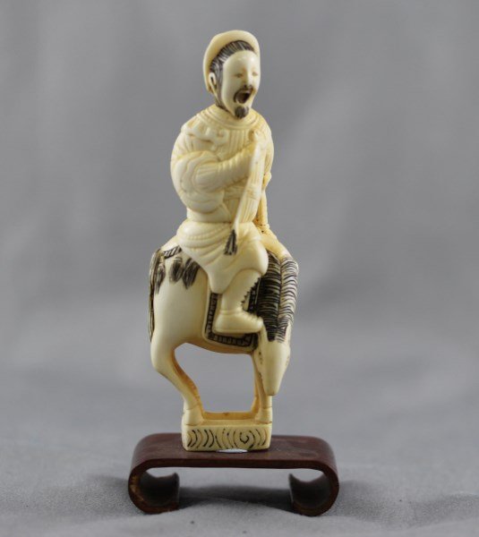 Good Ivory Netsuke,: in the form of a figure riding on the back of a horse, with etched and inked finish, on stand, h 9cm (not including stand height) Provenance: Mrs Betty Nelson Estate, Hong Kong 1947-1967